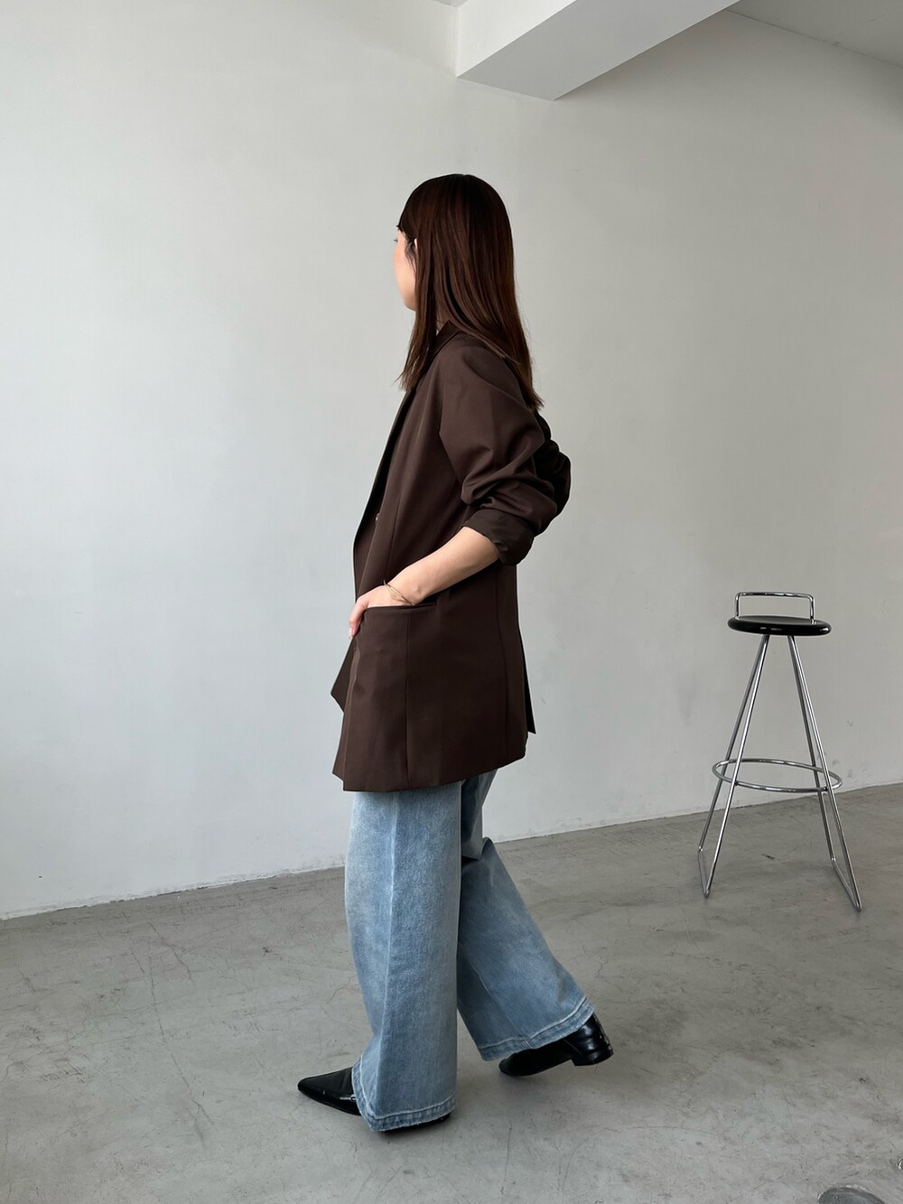 ブラウン系のテーラードジャケット、ブルー系のデニムパンツ、ブラック系のローファーを着用したレディースの秋コーディネートの4枚目の写真