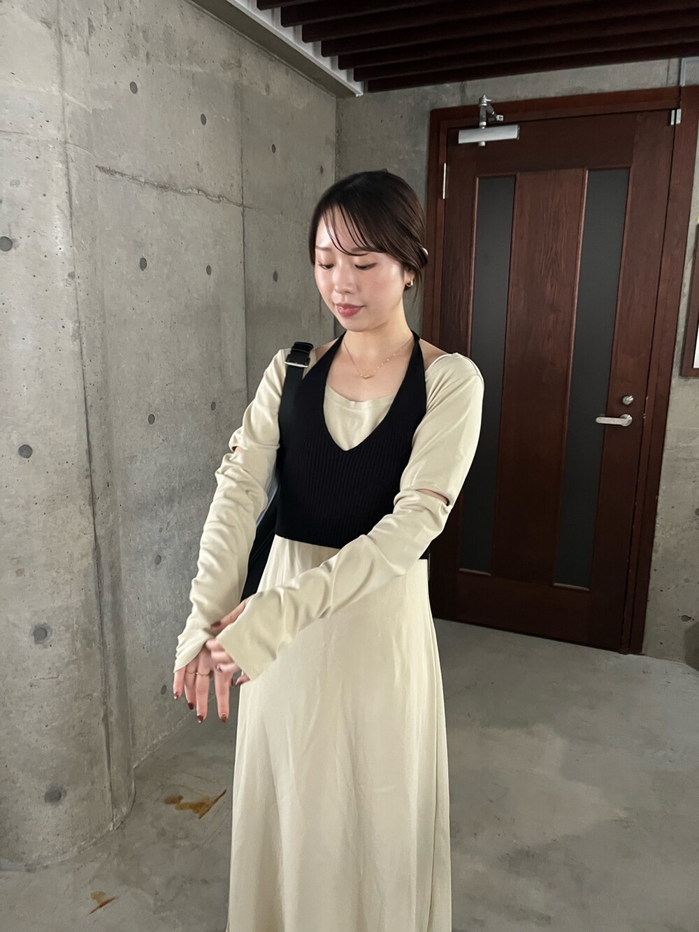 ベージュ系のワンピース、ブラック系のショルダーバッグ、ブラック系のブーツを着用したレディースの春コーディネートの5枚目の写真