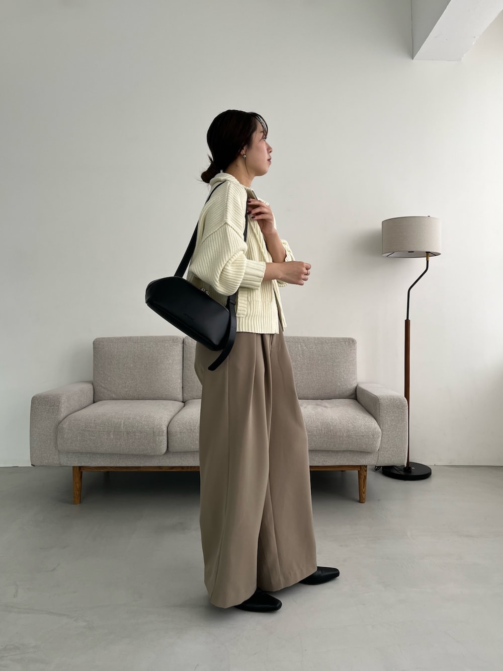 ベージュ系のその他パンツ、ホワイト系のカーディガン/ボレロ、ブラック系のショルダーバッグを着用したレディースの冬コーディネートの3枚目の写真