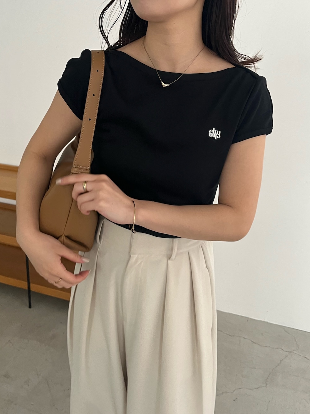ブラック系のTシャツ/カットソー、ホワイト系のその他パンツ、ブラック系のサンダルを着用したレディースの春コーディネートの5枚目の写真