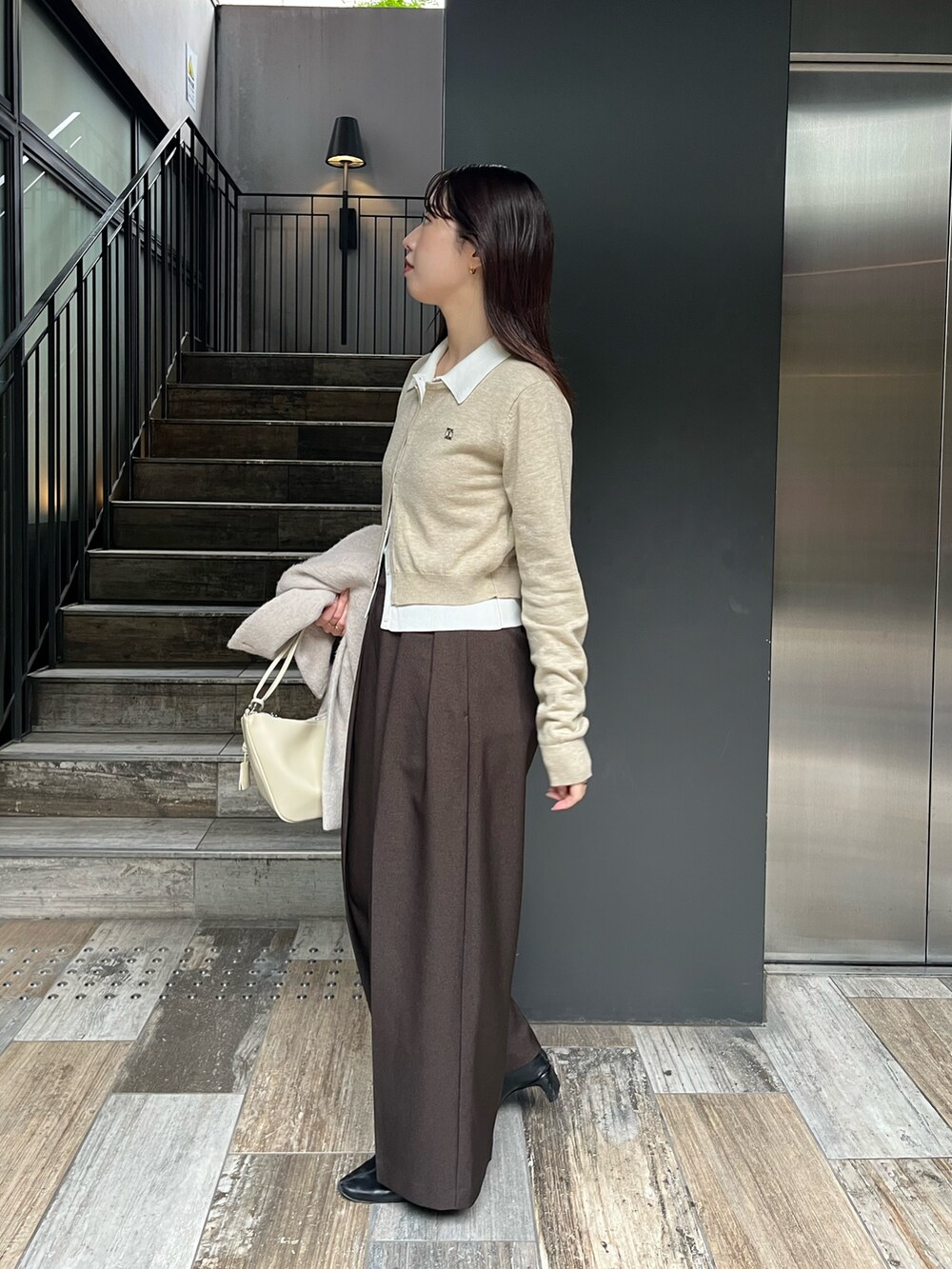 ベージュ系のカーディガン/ボレロ、ブラウン系のその他パンツ、ベージュ系のその他アウターを着用したレディースの冬コーディネートの4枚目の写真