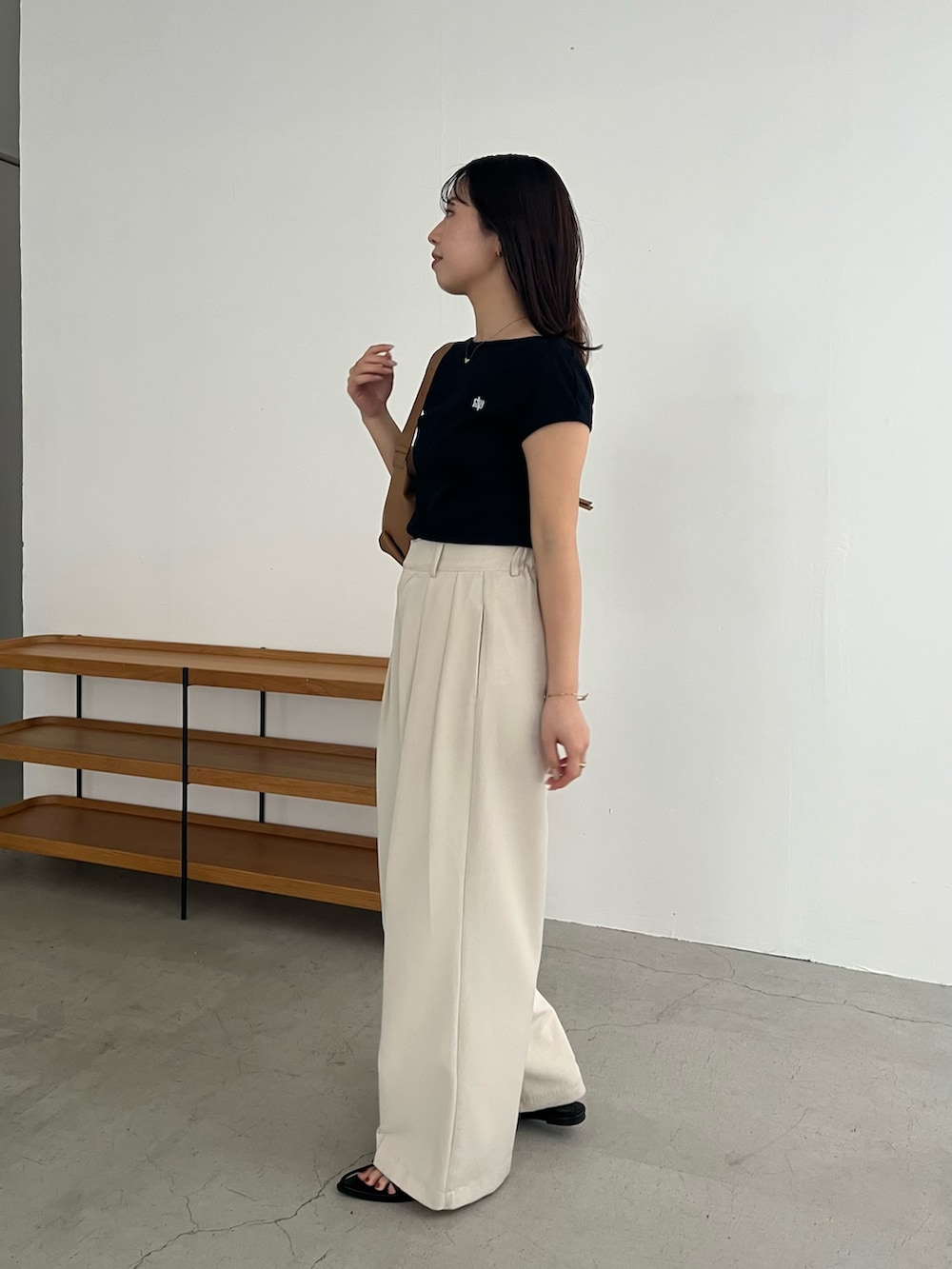 ブラック系のTシャツ/カットソー、ホワイト系のその他パンツ、ブラック系のサンダルを着用したレディースの春コーディネートの3枚目の写真