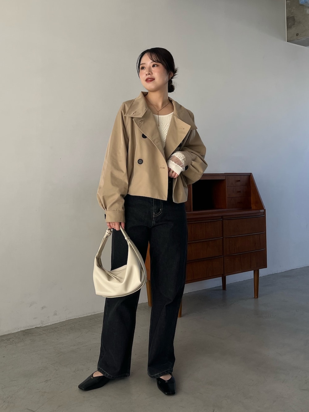 ブラック系のデニムパンツ、ブラック系のパンプス、ホワイト系のショルダーバッグを着用したレディースの冬コーディネートの5枚目の写真