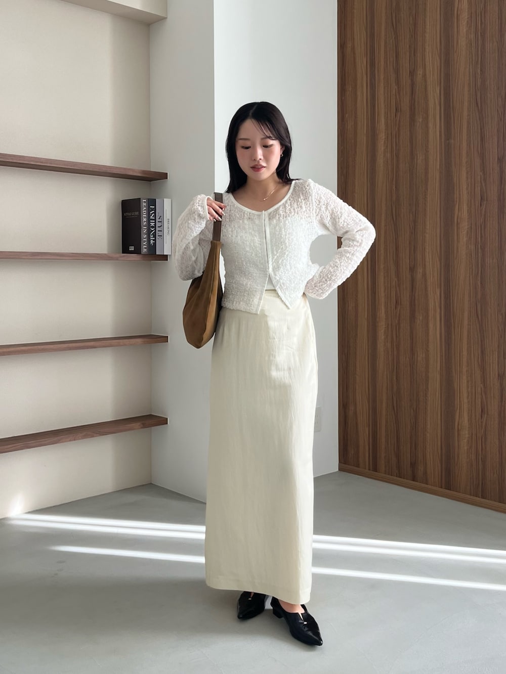 ホワイト系のシャツ/ブラウス、ホワイト系のスカート、ブラック系のパンプスを着用したレディースの春コーディネートの2枚目の写真