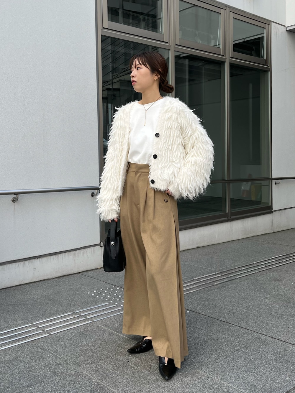 ベージュ系のその他パンツ、ブラック系のショルダーバッグ、ホワイト系のカーディガン/ボレロを着用したレディースの冬コーディネートの2枚目の写真