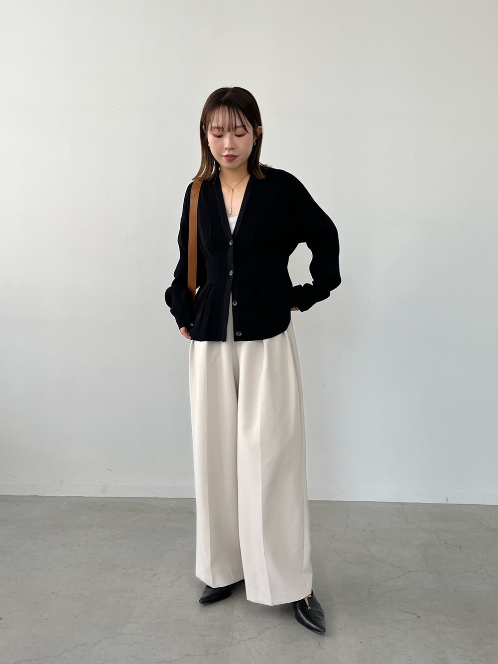ブラック系のカーディガン/ボレロ、ホワイト系のその他パンツ、ブラック系のパンプスを着用したレディースの冬コーディネートの3枚目の写真