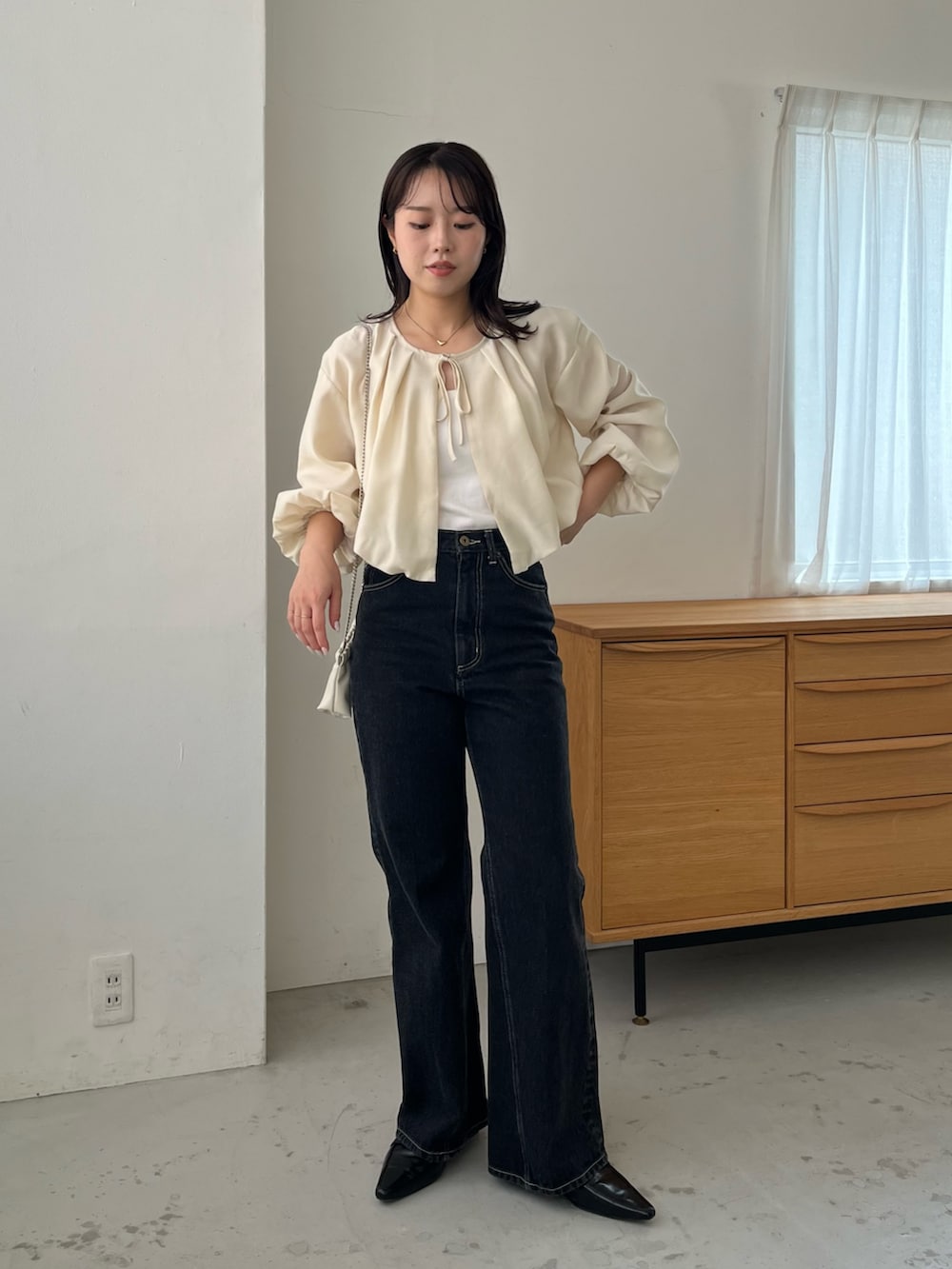ベージュ系のシャツ/ブラウス、ブラック系のローファー、ブラック系のデニムパンツを着用したレディースの秋コーディネートの3枚目の写真