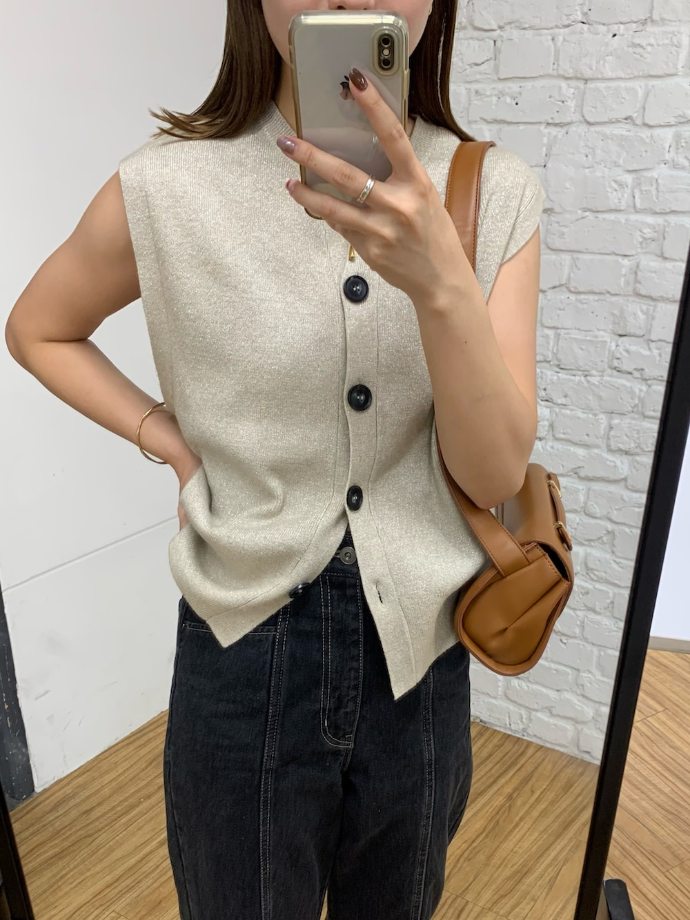 ベージュ系のニット/セーター、ブラック系のデニムパンツ、ブラック系のショルダーバッグを着用したレディースの秋コーディネートの4枚目の写真