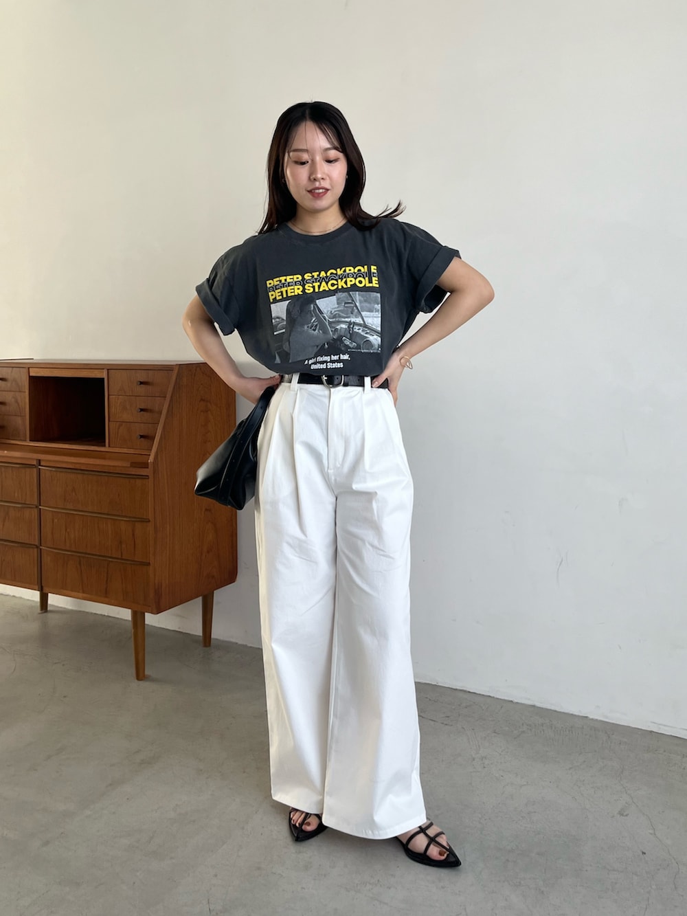 ブラック系のTシャツ/カットソー、ホワイト系のその他パンツ、ブラック系のサンダルを着用したレディースの春コーディネートの2枚目の写真