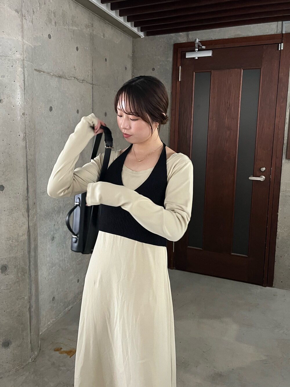 ベージュ系のワンピース、ブラック系のショルダーバッグ、ブラック系のブーツを着用したレディースの春コーディネートの3枚目の写真