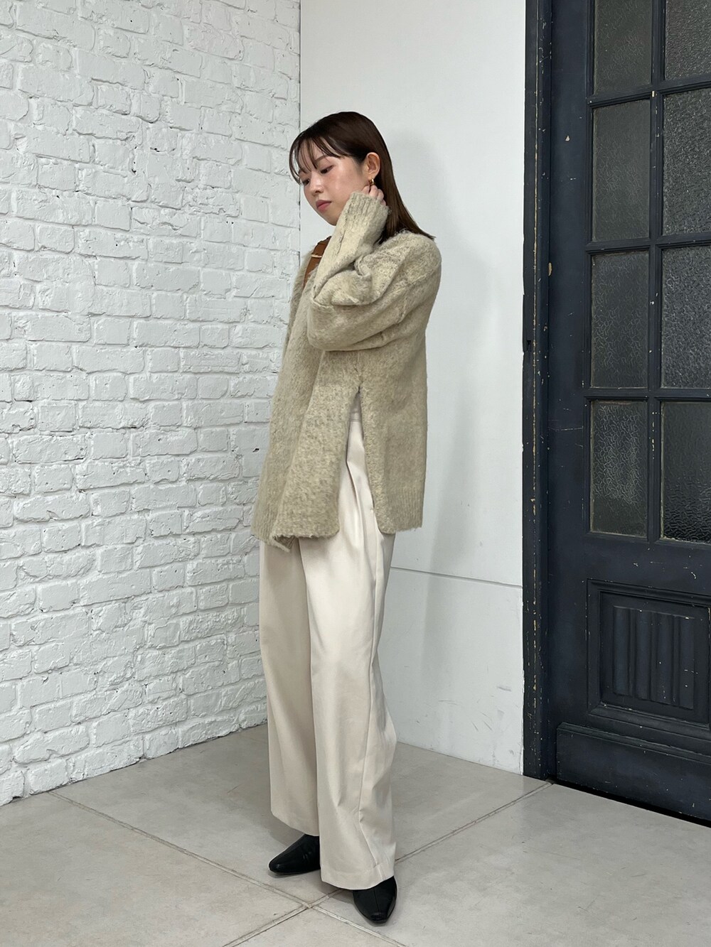 ベージュ系のニット/セーター、ホワイト系のその他パンツ、ベージュ系のショルダーバッグを着用したレディースの秋コーディネートの3枚目の写真