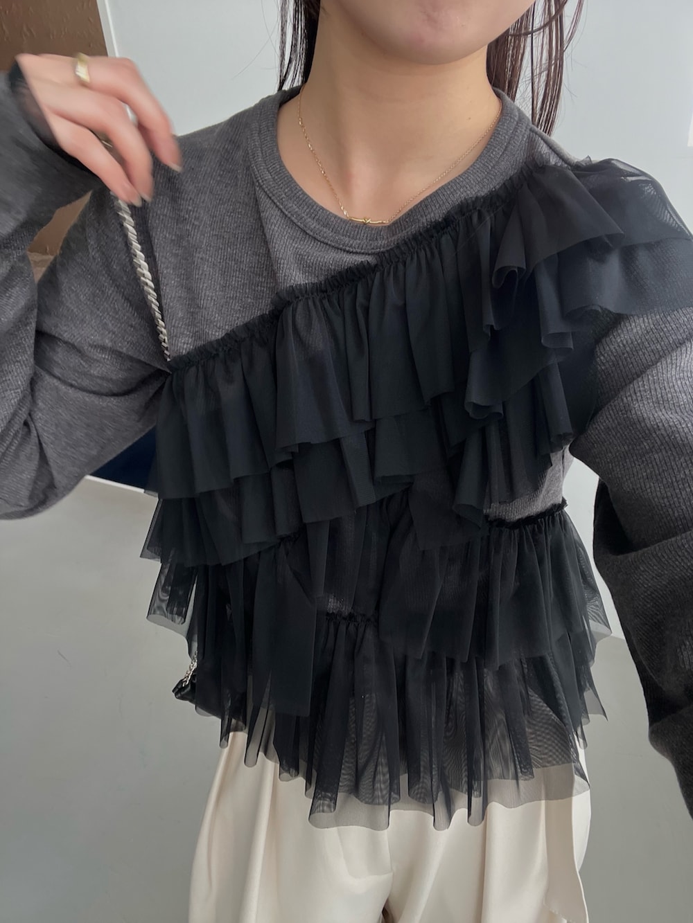 グレー系のTシャツ/カットソー、ホワイト系のその他パンツ、ブラック系のショルダーバッグを着用したレディースの春コーディネートの4枚目の写真