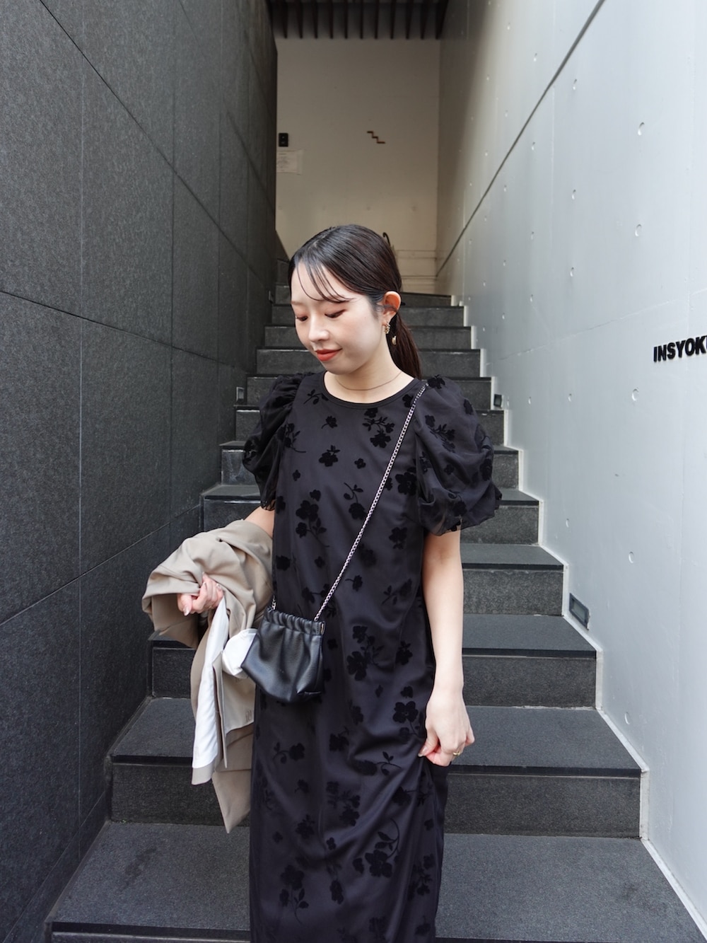 ブラック系のパンプス、ベージュ系のテーラードジャケット、ブラック系のワンピースを着用したレディースの春コーディネートの2枚目の写真