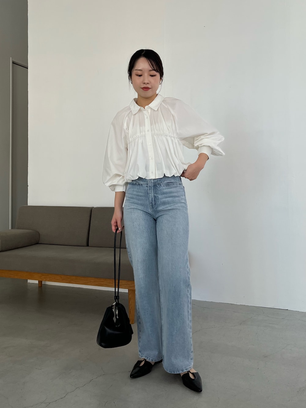 ホワイト系のシャツ/ブラウス、ブルー系のデニムパンツ、ブラック系のパンプスを着用したレディースの春コーディネートの5枚目の写真