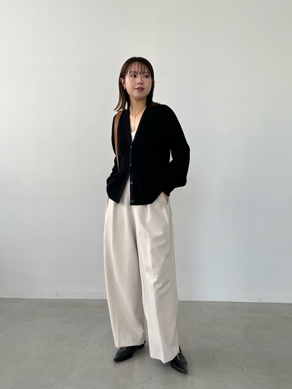 ブラック系のカーディガン/ボレロ、ホワイト系のその他パンツ、ブラック系のパンプスを着用したレディースの冬コーディネートの2枚目の写真