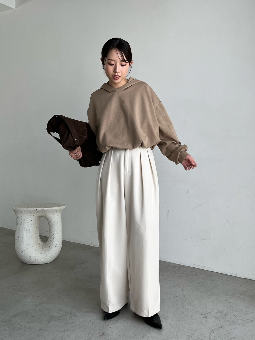 ベージュ系のTシャツ/カットソー、ブラック系のパンプス、ブラウン系のトートバッグを着用したレディースの秋コーディネートの3枚目の写真