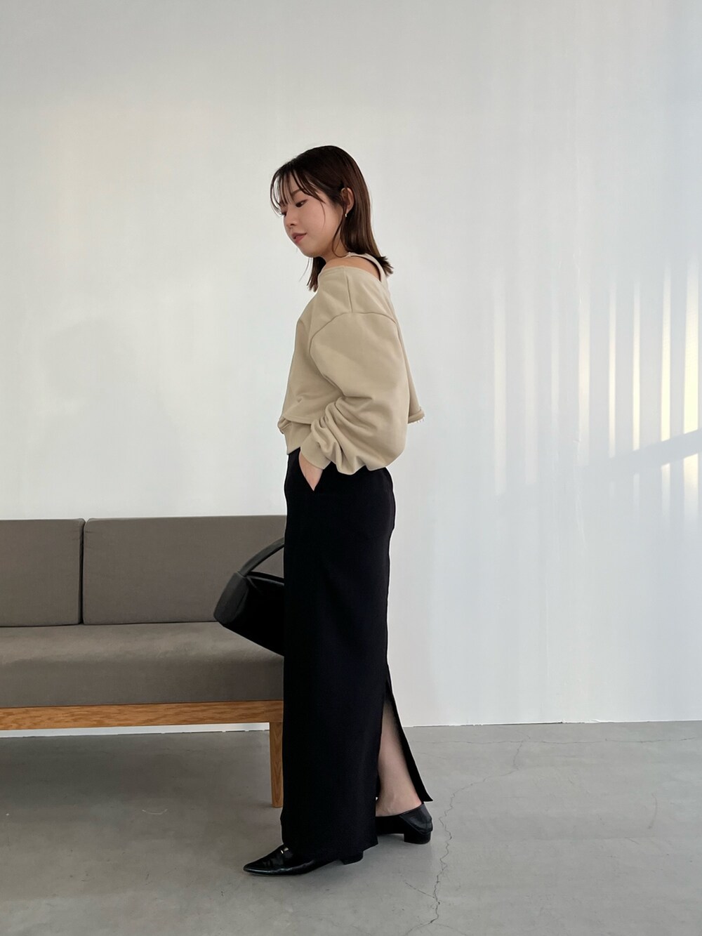 ベージュ系のスウェット、ブラック系のスカート、ブラック系のハンドバッグを着用したレディースの冬コーディネートの4枚目の写真