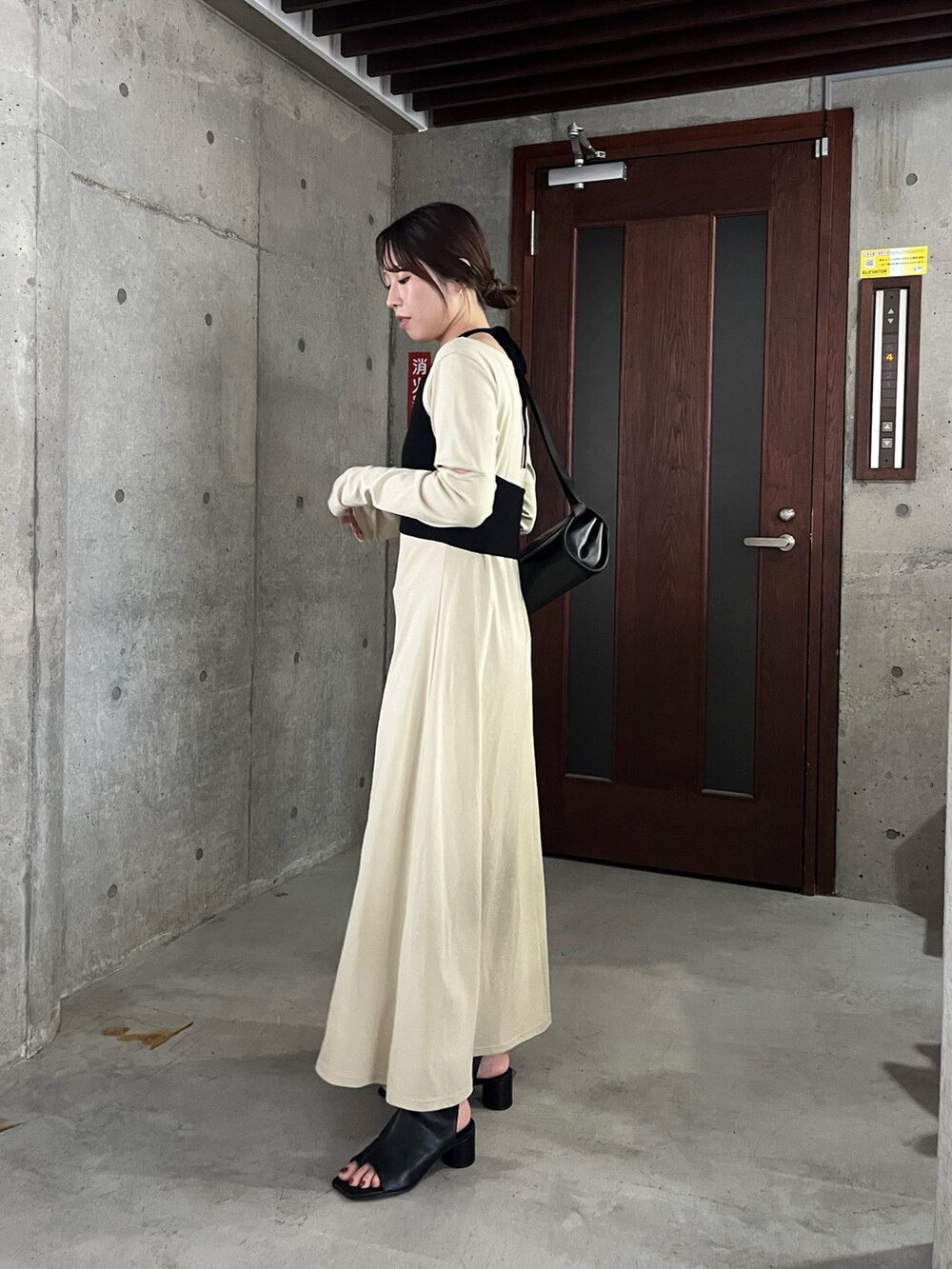 ベージュ系のワンピース、ブラック系のショルダーバッグ、ブラック系のブーツを着用したレディースの春コーディネートの4枚目の写真