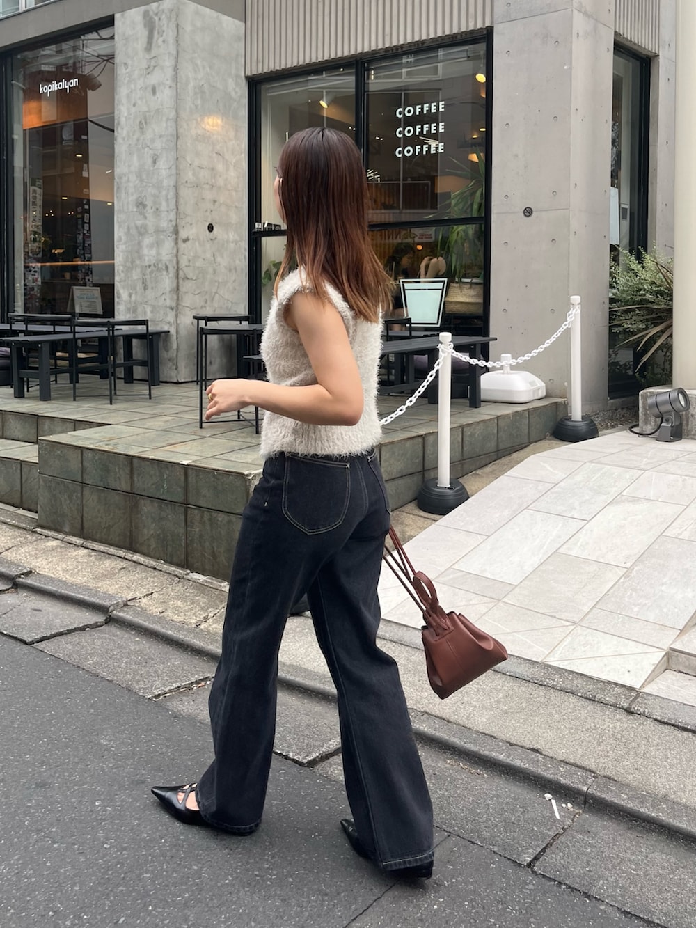 ベージュ系のニット/セーター、ブラック系のデニムパンツ、ブラック系のパンプスを着用したレディースの秋コーディネートの3枚目の写真