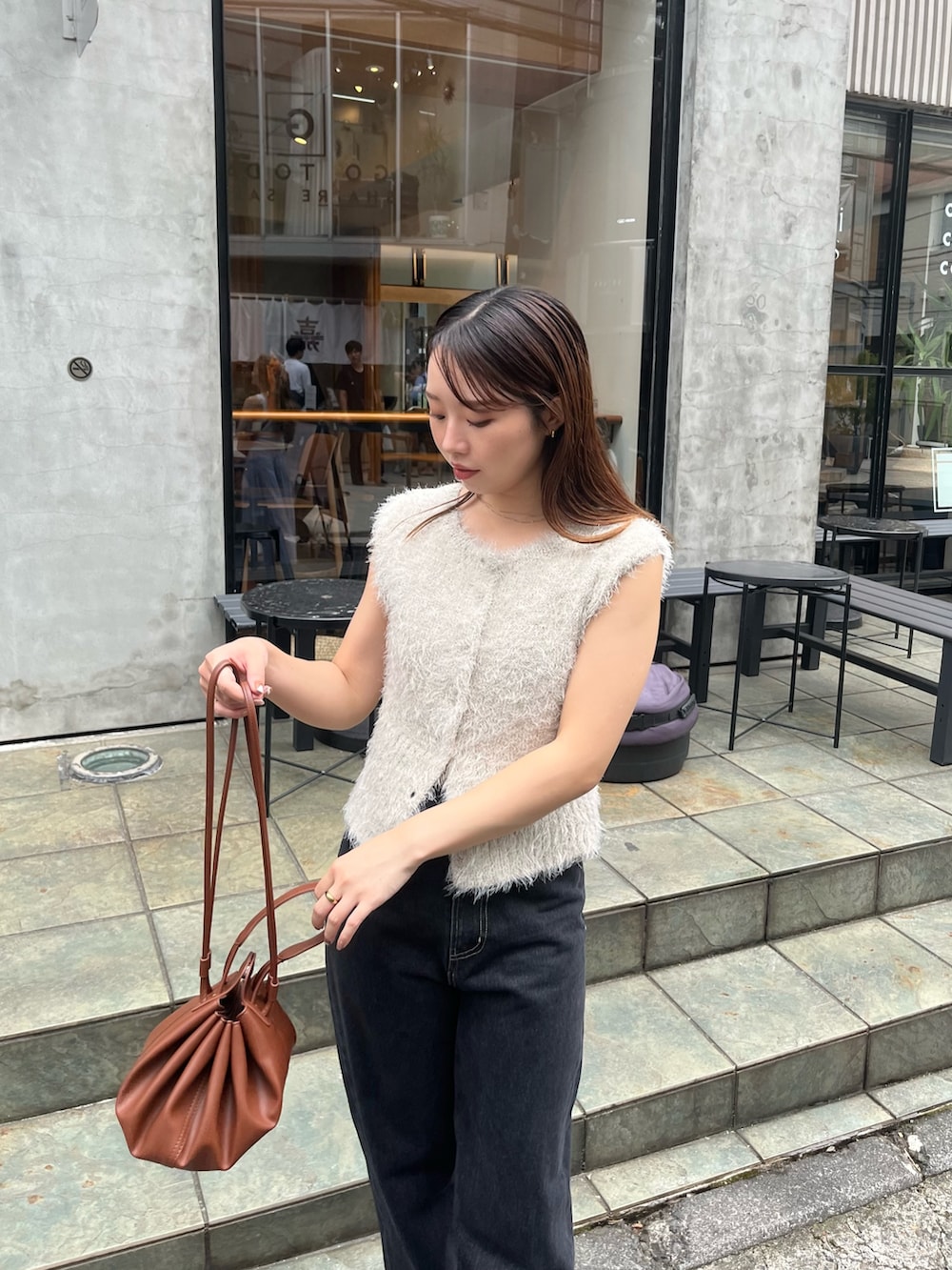 ベージュ系のニット/セーター、ブラック系のデニムパンツ、ブラック系のパンプスを着用したレディースの秋コーディネートの2枚目の写真