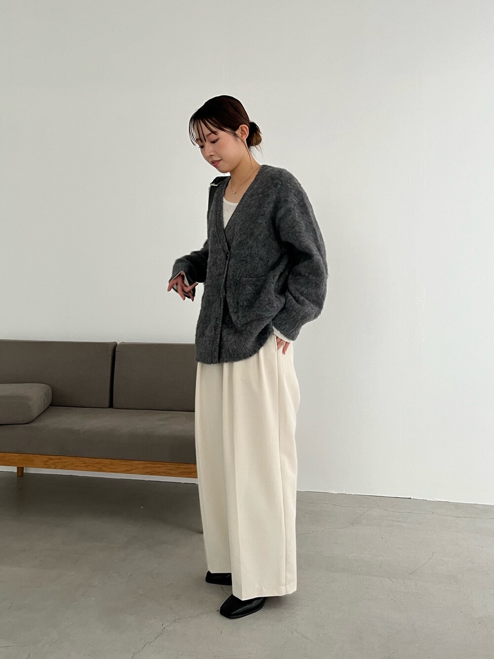 ホワイト系のTシャツ/カットソー、グレー系のカーディガン/ボレロ、ブラック系のショルダーバッグを着用したレディースの冬コーディネートの2枚目の写真