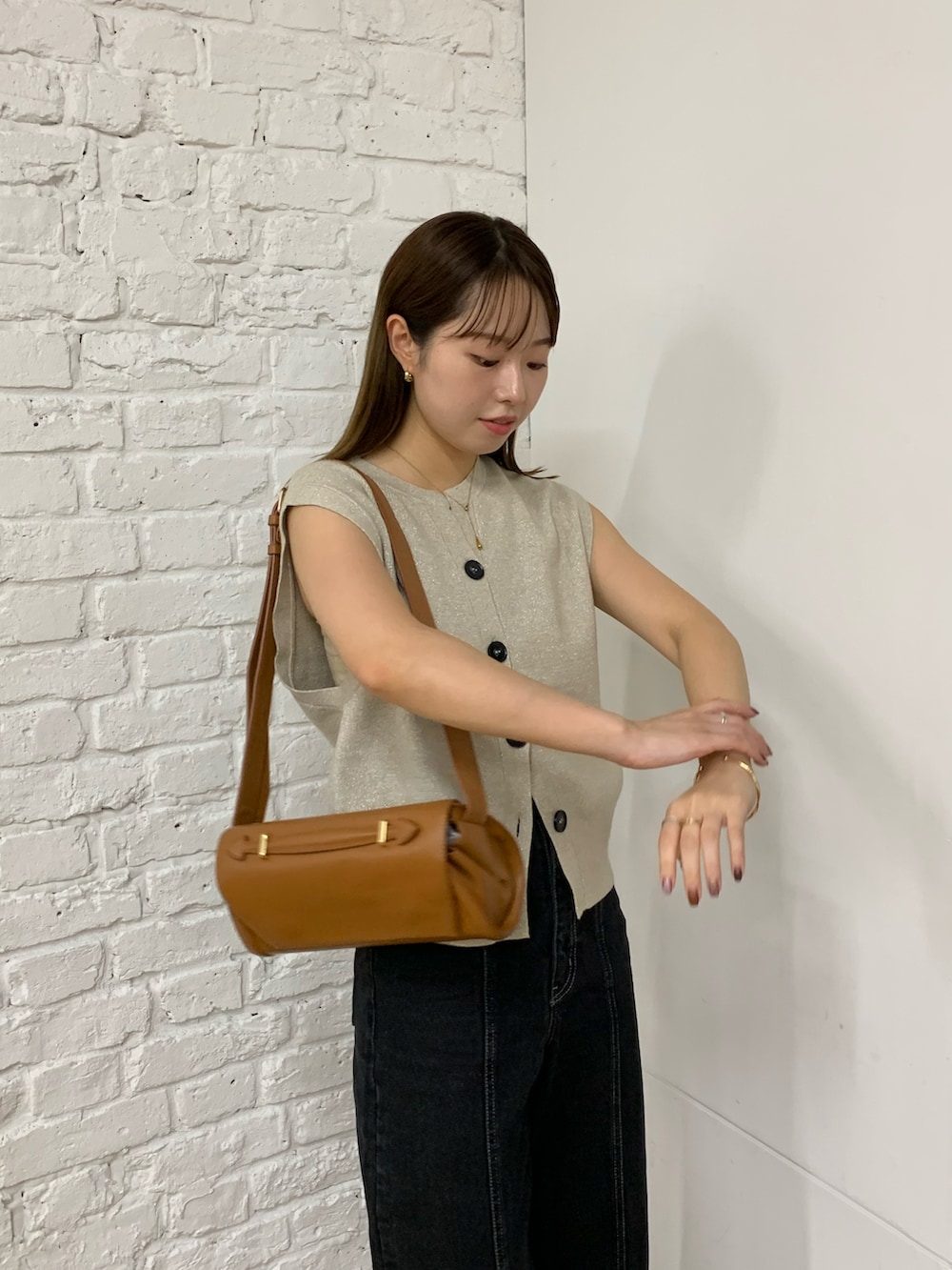 ベージュ系のニット/セーター、ブラック系のデニムパンツ、ブラック系のショルダーバッグを着用したレディースの秋コーディネートの5枚目の写真