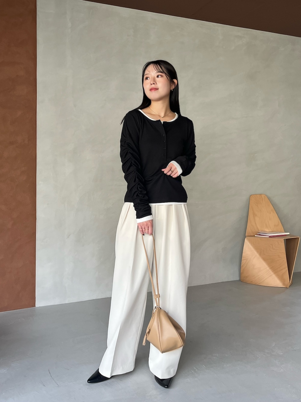 ブラック系のTシャツ/カットソー、ホワイト系のその他パンツ、ベージュ系のショルダーバッグを着用したレディースの冬コーディネートの3枚目の写真