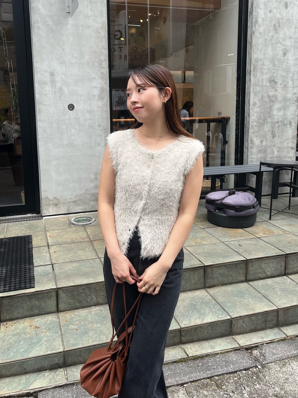 ベージュ系のニット/セーター、ブラック系のデニムパンツ、ブラック系のパンプスを着用したレディースの秋コーディネートの5枚目の写真