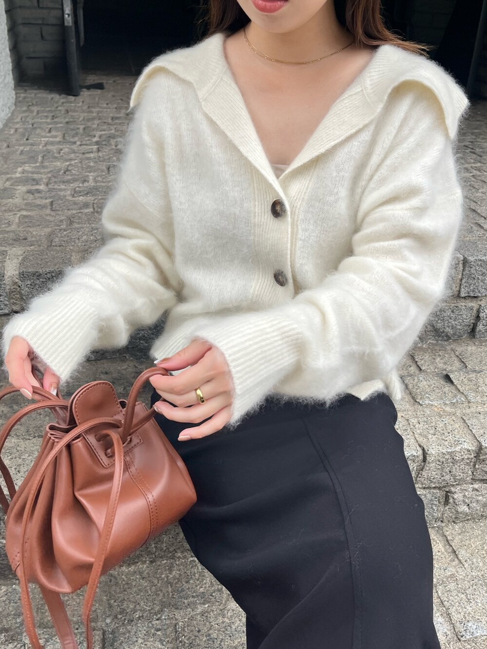 ホワイト系のカーディガン/ボレロ、ブラック系のパンプス、ブラック系のスカートを着用したレディースの秋コーディネートの4枚目の写真