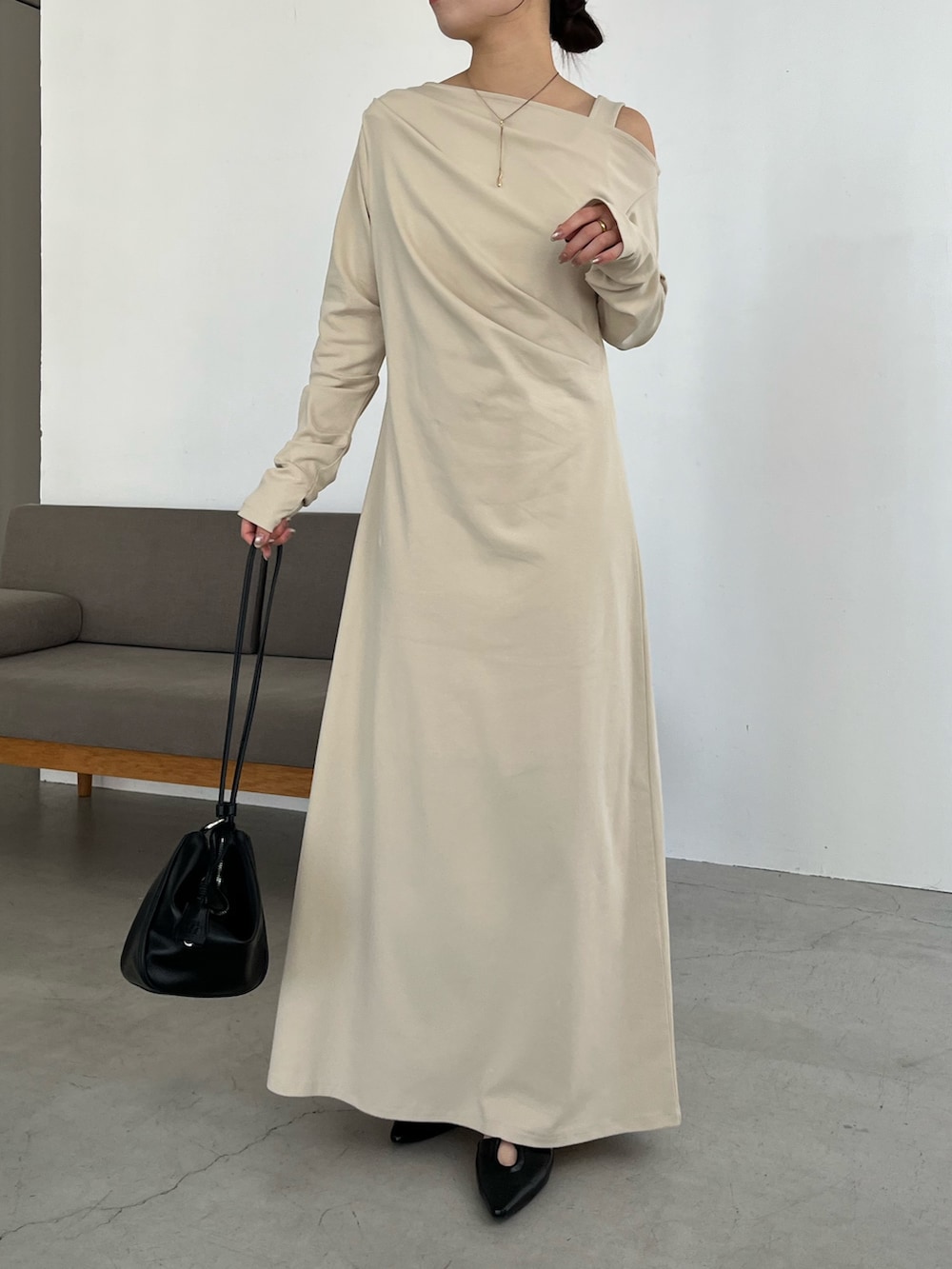 ベージュ系のワンピース、ブラック系のパンプスを着用したレディースの春コーディネートの2枚目の写真