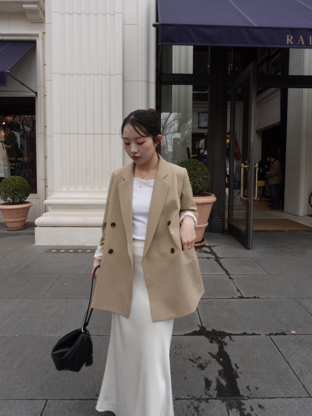 ホワイト系のTシャツ/カットソー、ベージュ系のテーラードジャケット、ホワイト系のスカートを着用したレディースの春コーディネートの2枚目の写真