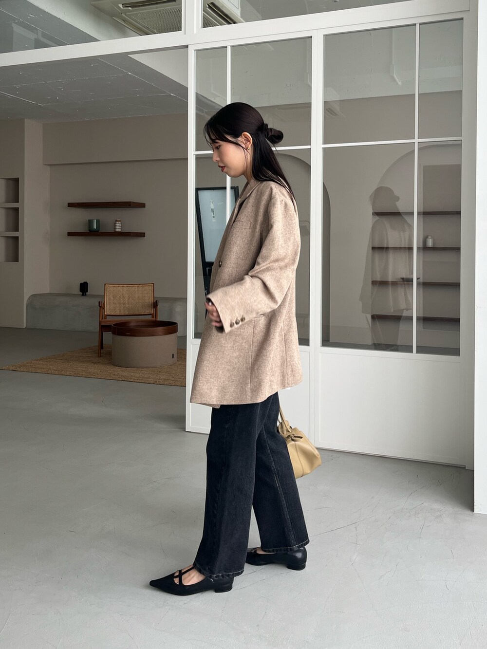 ベージュ系のテーラードジャケット、ブラック系のデニムパンツ、ブラック系のパンプスを着用したレディースの秋コーディネートの4枚目の写真