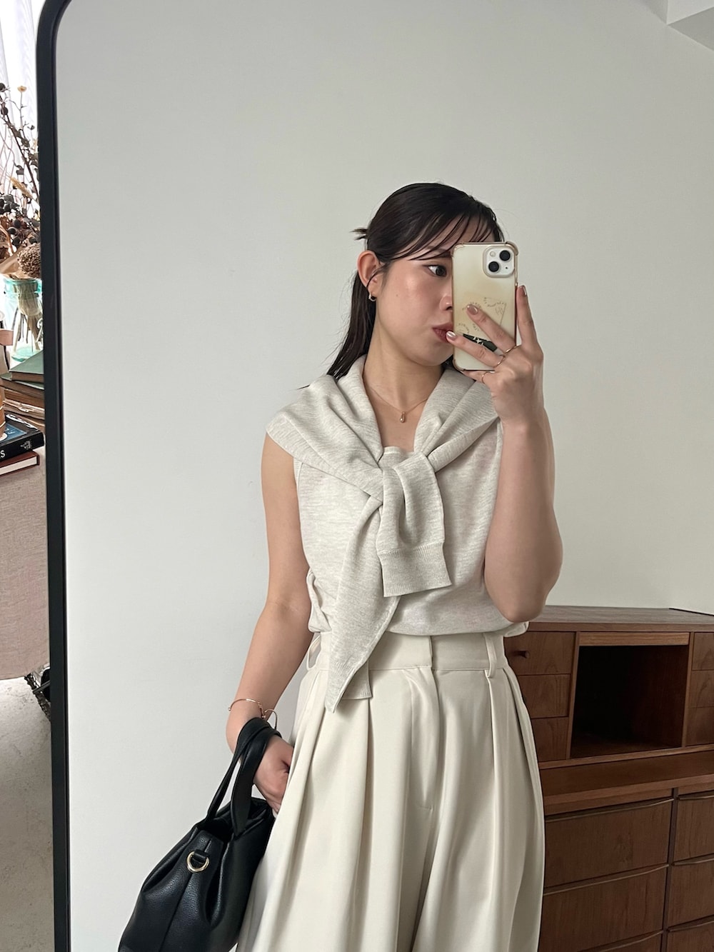 ホワイト系のニット/セーター、ホワイト系のその他パンツ、ブラック系のサンダルを着用したレディースの夏コーディネートの3枚目の写真