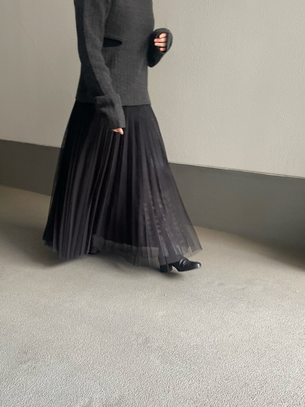 グレー系のニット/セーター、ブラック系のスカートを着用したレディースの冬コーディネートの3枚目の写真