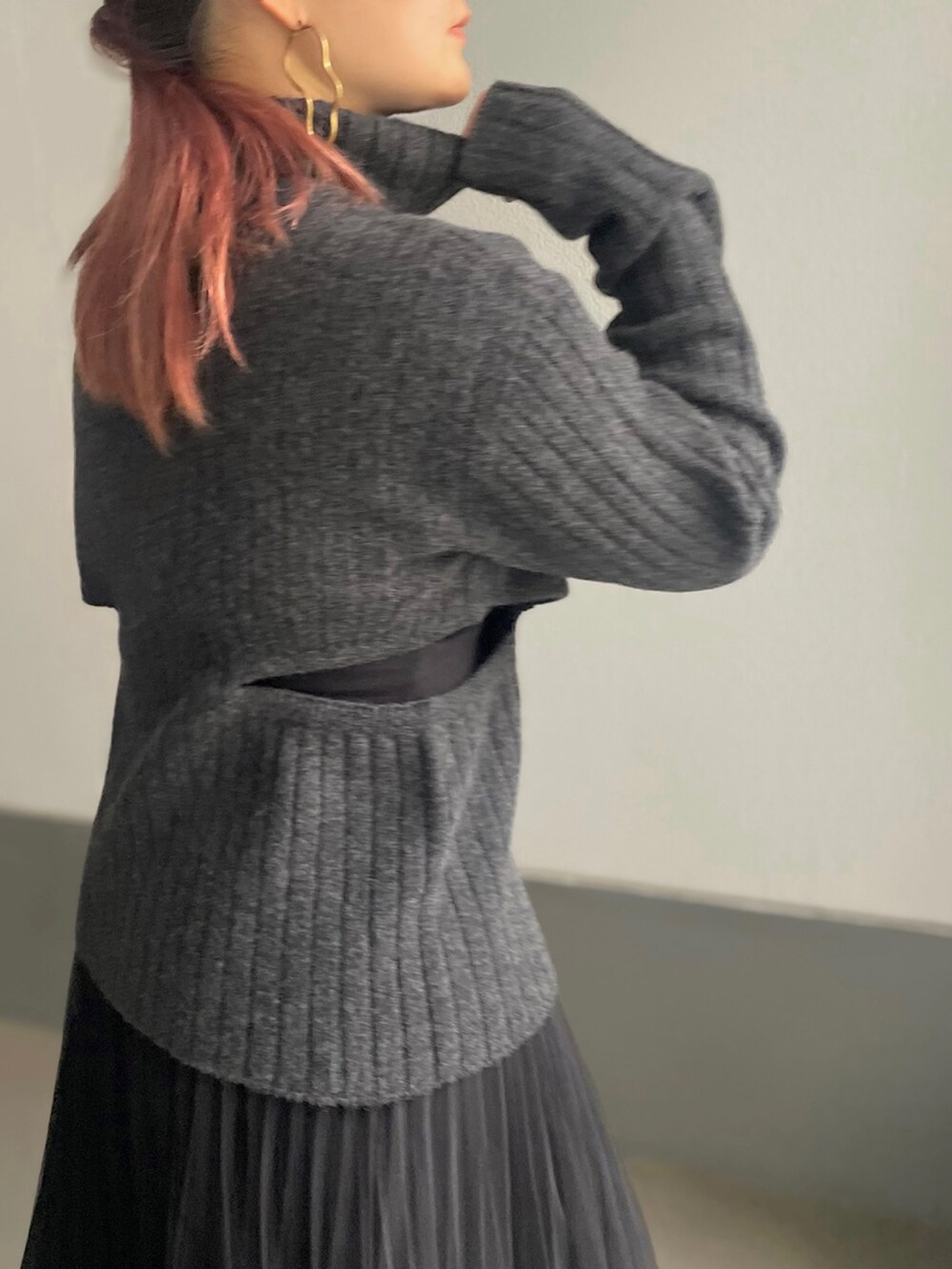 グレー系のニット/セーター、ブラック系のスカートを着用したレディースの冬コーディネートの2枚目の写真