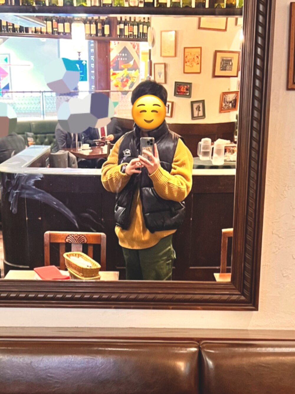 グリーン系のカーゴパンツ、ブラック系のダウンベスト、グレー系のスニーカーを着用したメンズの冬コーディネートの3枚目の写真