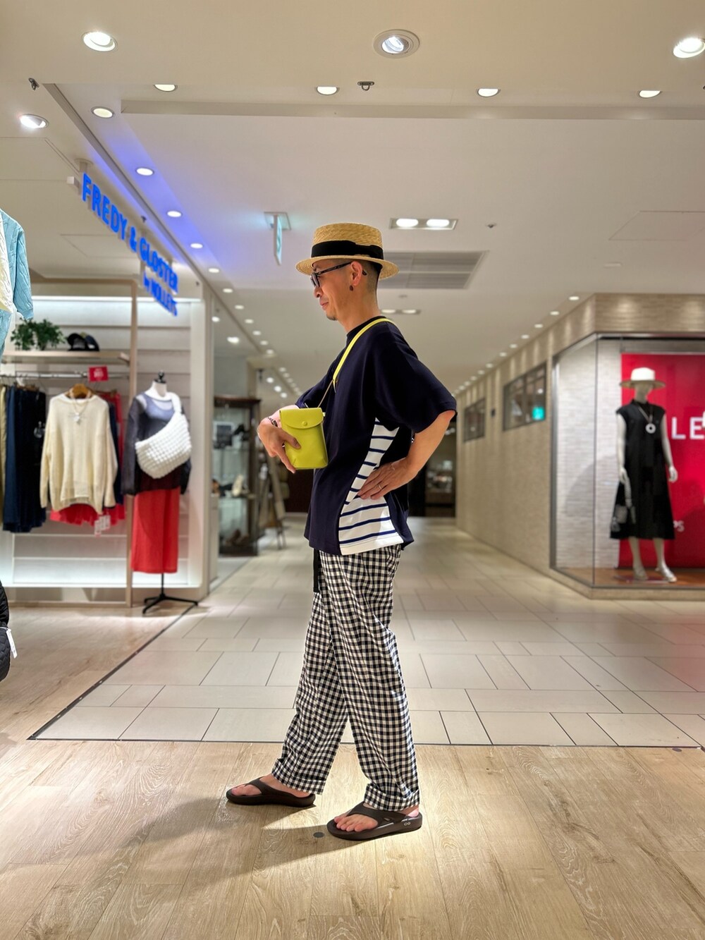ブルー系のTシャツ/カットソー、イエロー系のショルダーバッグ、ベージュ系のハットを着用したメンズの夏コーディネートの3枚目の写真