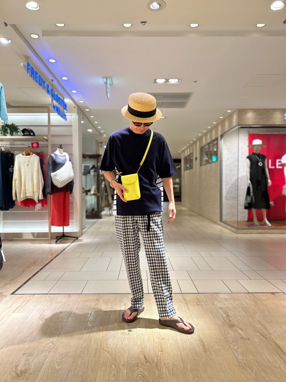 ブルー系のTシャツ/カットソー、イエロー系のショルダーバッグ、ベージュ系のハットを着用したメンズの夏コーディネートの2枚目の写真