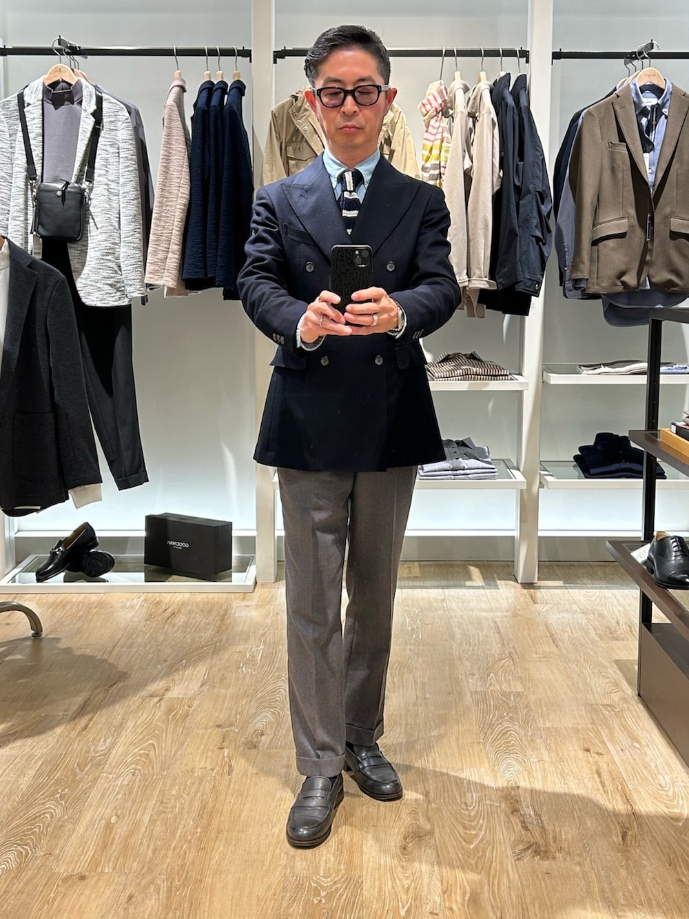 ベージュ系のステンカラーコート、ブルー系のテーラードジャケットを着用したメンズの冬コーディネートの3枚目の写真