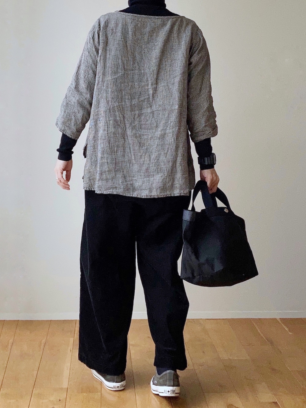 ブラック系のトートバッグ、ブラック系のスニーカー、ブラック系のその他パンツを着用したレディースの冬コーディネートの3枚目の写真