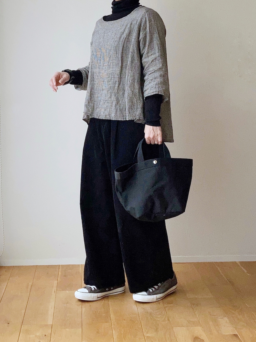 ブラック系のトートバッグ、ブラック系のスニーカー、ブラック系のその他パンツを着用したレディースの冬コーディネートの2枚目の写真