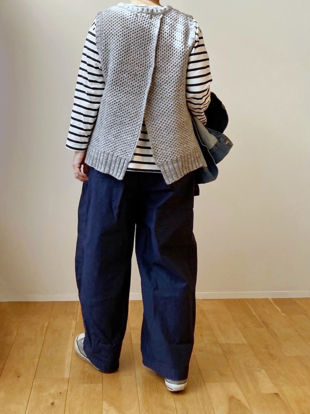 グレー系のベスト、グリーン系のその他パンツ、グレー系のスニーカーを着用したレディースの冬コーディネートの2枚目の写真