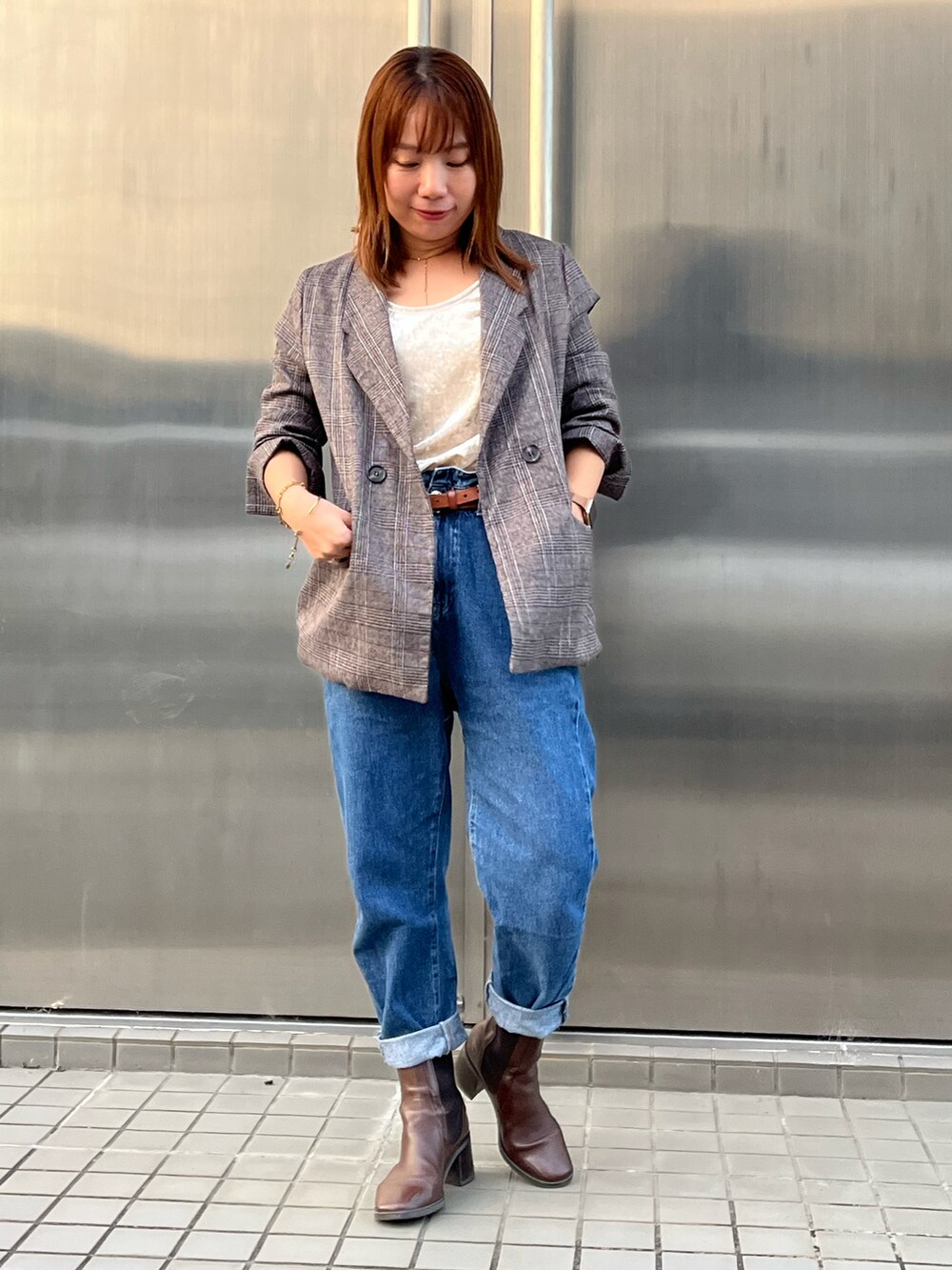 ベージュ系のTシャツ/カットソー、ブルー系のデニムパンツ、ブラウン系のブーツを着用したレディースの秋コーディネートの2枚目の写真
