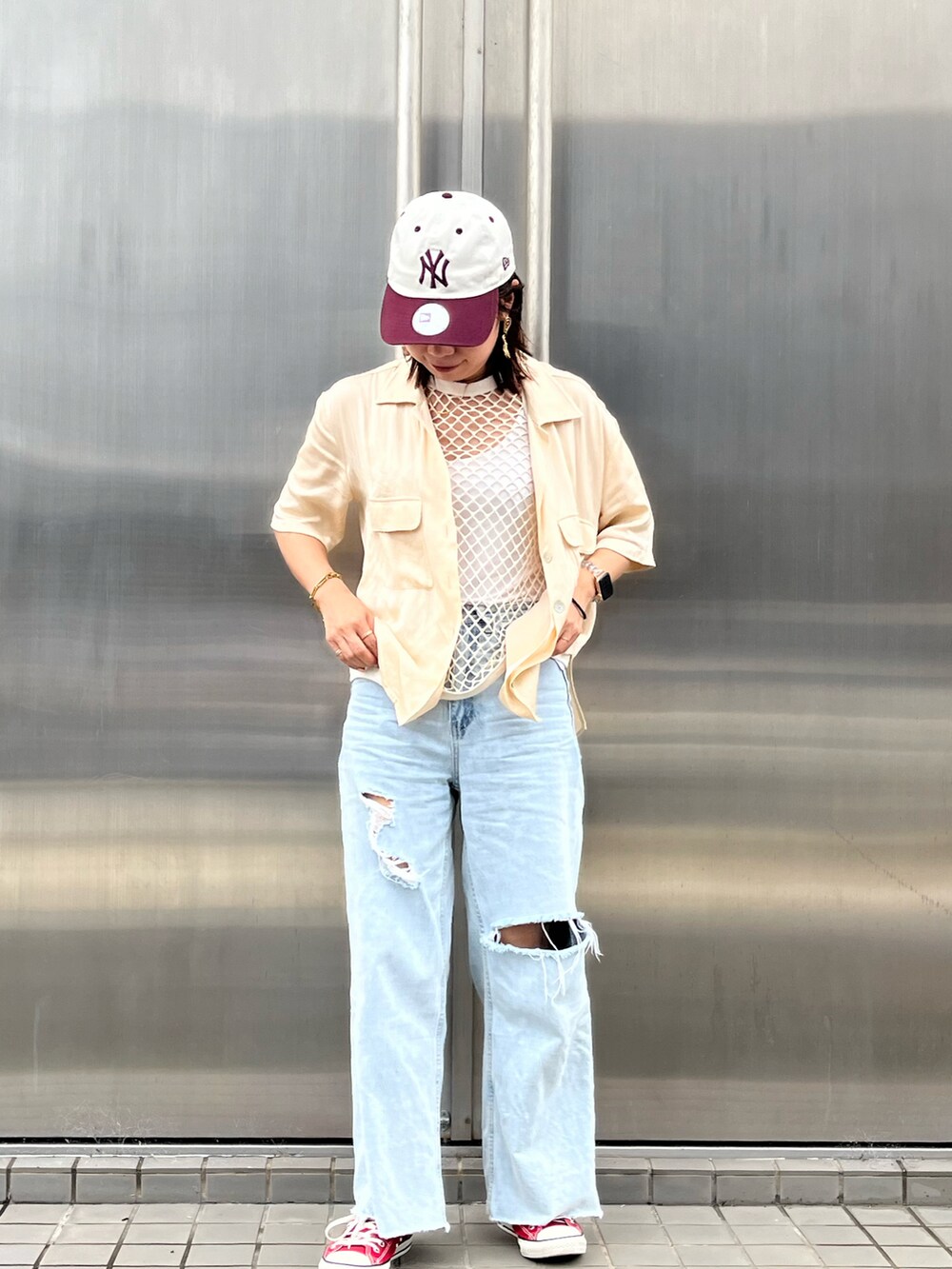 ベージュ系のタンクトップ、ブルー系のデニムパンツ、レッド系のスニーカーを着用したレディースの夏コーディネートの2枚目の写真