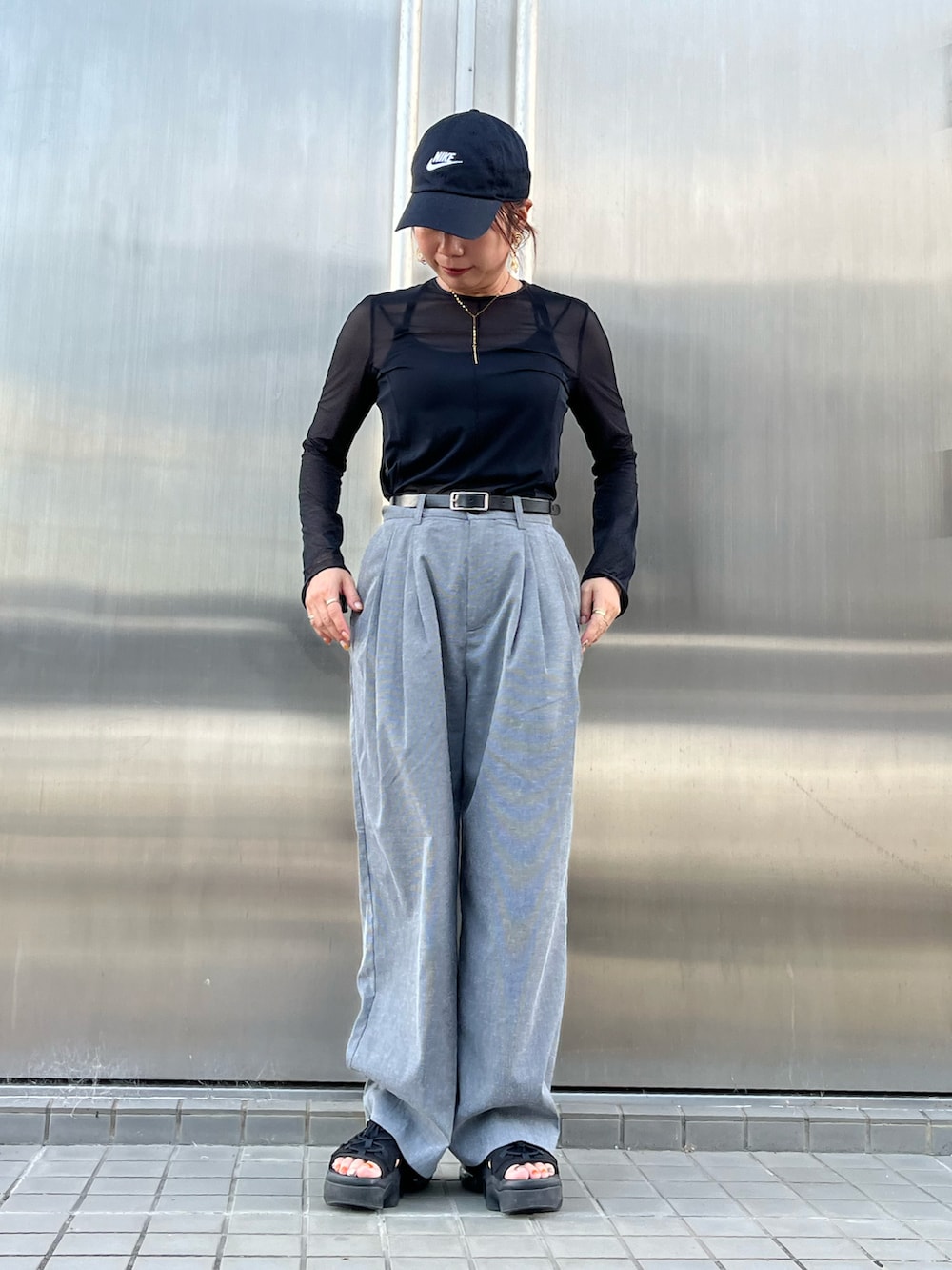 グレー系のパンツ、ブラック系のサンダル、ブラック系のTシャツ/カットソーを着用したレディースの夏コーディネートの2枚目の写真