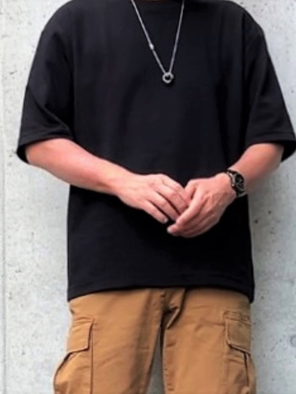 ブラック系のTシャツ/カットソー、ベージュ系のカーゴパンツ、ブラック系のブーツを着用したメンズの夏コーディネートの2枚目の写真