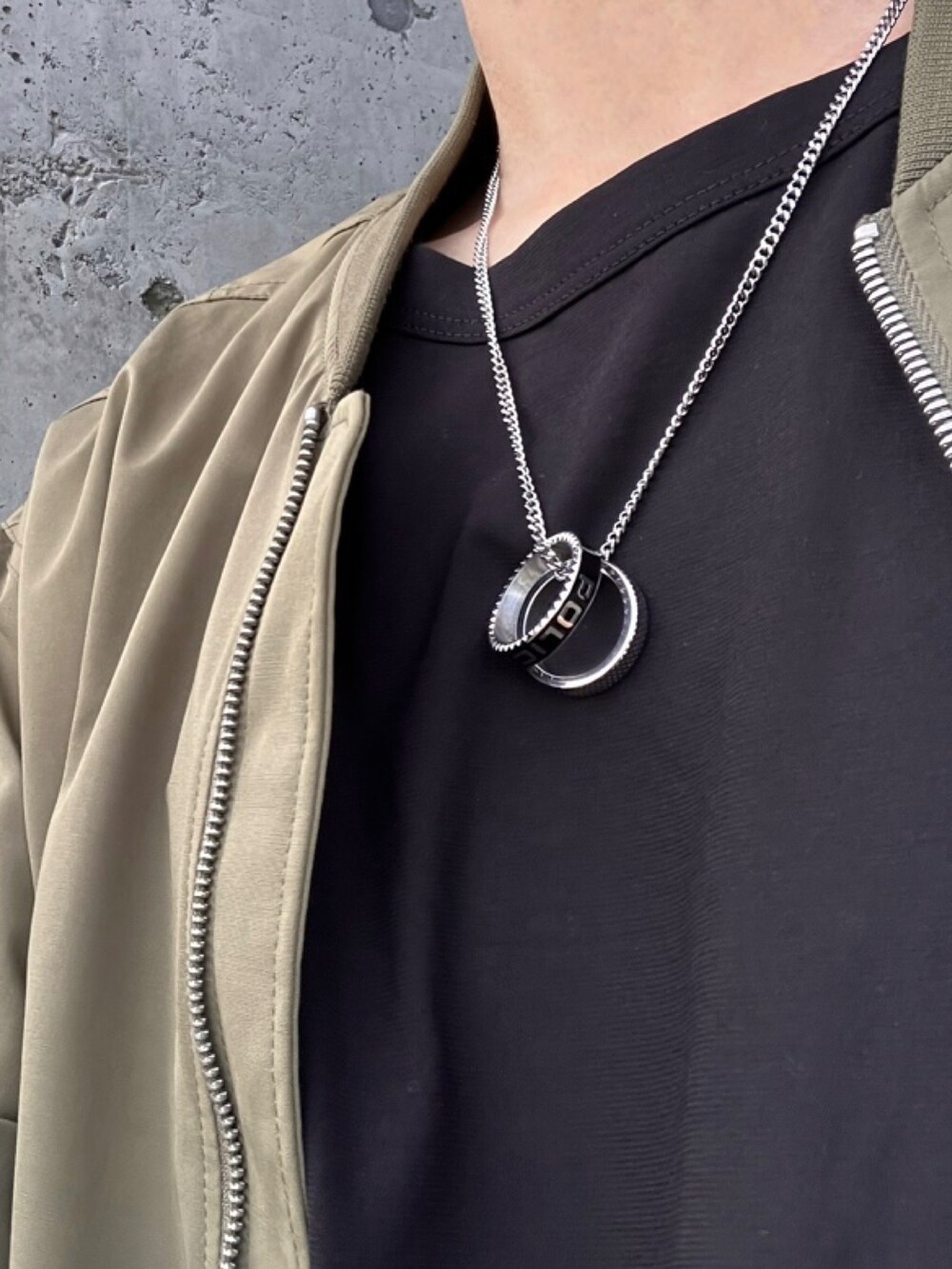 ブルー系のデニムパンツ、グリーン系のブルゾン、ブラック系のTシャツ/カットソーを着用したメンズの秋コーディネートの2枚目の写真