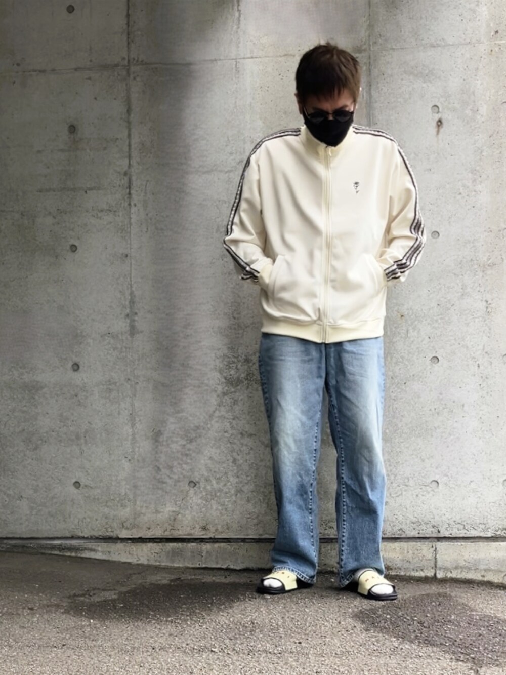 ベージュ系のジャージ、ブルー系のデニムパンツ、その他のサンダルを着用したメンズの春コーディネートの2枚目の写真