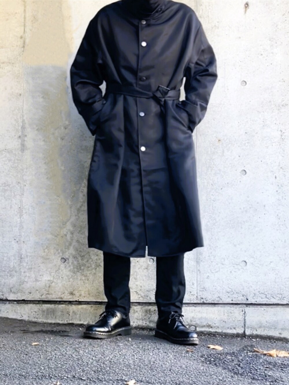 ブラック系のステンカラーコート、ブラック系のデニムパンツ、ブラック系のその他シューズを着用したメンズの冬コーディネートの5枚目の写真