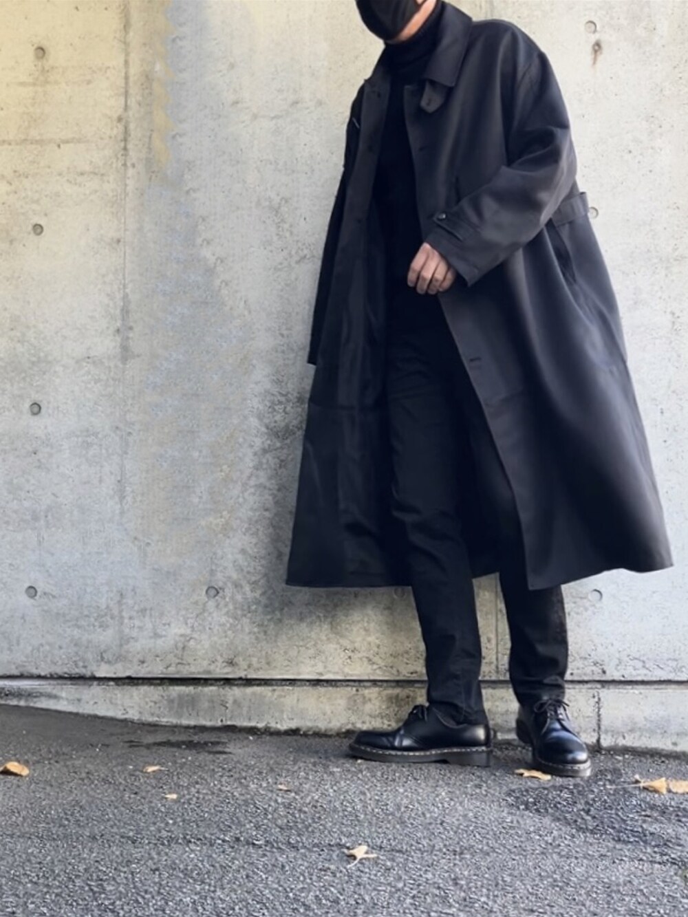 ブラック系のステンカラーコート、ブラック系のデニムパンツ、ブラック系のその他シューズを着用したメンズの冬コーディネートの4枚目の写真